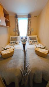 two twin beds in a room with a window at 17 Ruby Atlas Monreith in Monreith