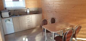 a kitchen with a table and chairs and a sink at Nautica in Gąski