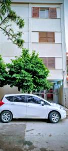 een witte auto geparkeerd voor een gebouw bij El Valtodano de Nueva Córdoba in La Porteña