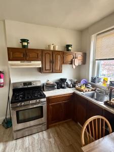 a kitchen with wooden cabinets and a stove top oven at Pleasant Rooming House in Washington