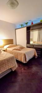 een hotelkamer met twee bedden en een spiegel bij El Valtodano de Nueva Córdoba in La Porteña