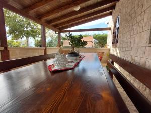 una mesa de madera en un porche con una planta encima en Villa Bellocchio, en Locorotondo