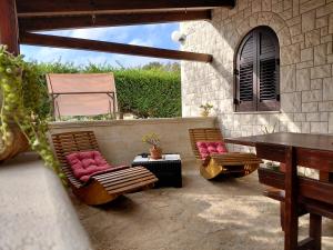 un patio con 2 sillas, una mesa, una mesa y una mesa en Villa Bellocchio, en Locorotondo
