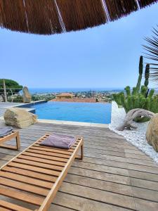 a wooden deck with a swimming pool and a roof at Villa Paradiso by Monarca Prestige in Furiani