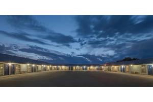 an empty parking lot at night with a cloudy sky at American Inn by Hotel O Vernon US 287 in Vernon