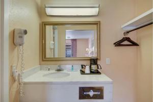 a bathroom with a sink and a mirror at American Inn by Hotel O Vernon US 287 in Vernon