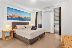 Un dormitorio con una cama y un cuadro en la pared. en Goudhaen Luxury Private apartments Jan Thiel Beach, en Jan Thiel 116 fotos más