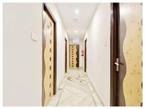 布巴内什瓦尔Hotel PVR inn Bhubaneswar- Near railway station with Premium facility#Top Rated Hotel Inn Bhubaneswar的一条空荡荡的走廊，有一扇门，走廊长度
