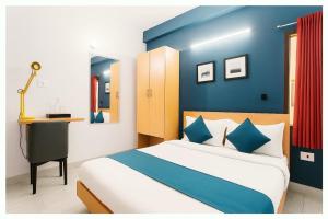 布巴内什瓦尔Hotel PVR inn Bhubaneswar- Near railway station with Premium facility#Top Rated Hotel Inn Bhubaneswar的蓝色和白色的卧室配有一张床和一张书桌