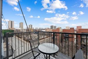 einen Tisch und Stühle auf einem Balkon mit Stadtblick in der Unterkunft Spacious 3BR Urban Getaway w Gym in Chicago