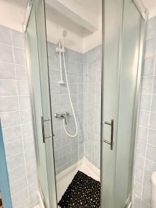 a shower with a glass door in a bathroom at JSG Locations in Sainte-Anne