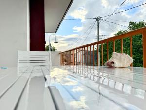 a glass table on a balcony with a view of the sky at JSG Locations in Sainte-Anne