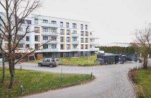 un coche aparcado delante de un gran edificio en SkyTravel 26 Apartament Pileckiego Nowy Dwór Mazowiecki Airport Modlin 24H, en Nowy Dwór Mazowiecki