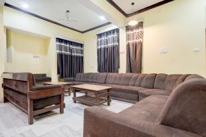 Hotel O Buddha Statue Gaya Formerly Uruvela International في بود جايا: غرفة معيشة مع أريكة وبيانو