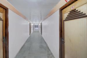 Hotel O Buddha Statue Gaya Formerly Uruvela International في بود جايا: ممر طويل بجدران بيضاء وممر طويل