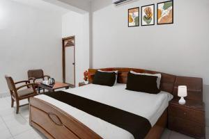 菩提伽耶Hotel O Buddha Statue Gaya Formerly Uruvela International的一间卧室，里面有一张床、一张桌子和一把椅子