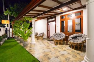 a patio with a bunch of chairs and grass at Lira Unawatuna in Unawatuna