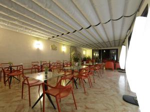 una sala da pranzo con tavoli, sedie e soffitto di Best Western Hotel Martello a Lampedusa