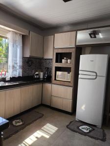 伊瓜苏Casa aconchego的厨房配有白色冰箱和窗户