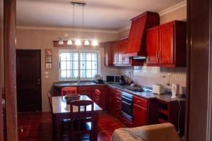 a kitchen with red cabinets and a table in it at D'Ouro Meu House in Sabrosa