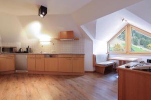 a kitchen with wooden floors and a large window at Chalet Madlein in Ischgl