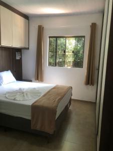 伊瓜苏Casa aconchego的带一张床和两扇窗户的卧室