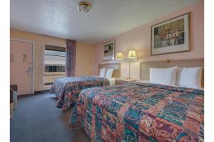 a hotel room with two beds and a window at American Inn by Hotel O Vernon US 287 in Vernon