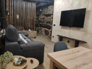 a living room with a couch and a tv on a wall at Bosque animado in La Alberca