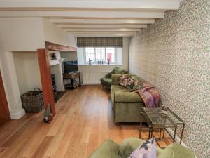 a living room with two couches and a table at Inglenook Cottage in Guisborough