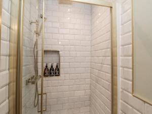 a bathroom with a shower with three bottles of wine at Inglenook Cottage in Guisborough +34 photos