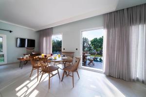 een eetkamer met een tafel en stoelen en een groot raam bij Villa Mira in Ovacik