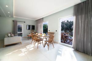 een woonkamer met een tafel, stoelen en een bank bij Villa Mira in Ovacik