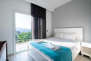 een slaapkamer met een bed en een groot raam bij Villa Mira in Ovacik +17 foto's