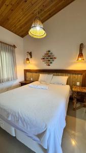 a bedroom with a large white bed in a room at Pousada Caponga Praia Mar in Cascavel +3 photos