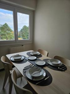 a dining room table with plates and utensils on it at Appartement T2 in Le Creusot