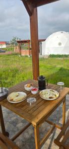 ein hölzerner Picknicktisch mit Tellern voller Essen darauf in der Unterkunft Enxe Glamping & Spa 