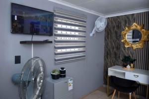 a room with a fan and a desk and a window at Hlurile Lodge in Vosburg +22 photos