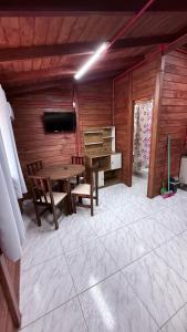 ein Holzzimmer mit einem Tisch und einem Klavier in der Unterkunft Hospedaria Oceania in Bombinhas