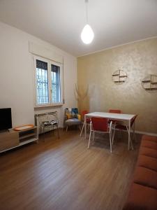 ein Wohnzimmer mit Tisch und Stühlen und einem Fernseher in der Unterkunft Milano Apartment - CarliHaus in Mailand
