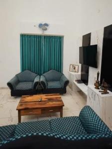 KandogalThe Chirping Sal Villa, by ShivStuti HomeStays的客厅里有一张沙发和一张桌子。