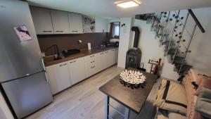 Una cocina con un refrigerador y una mesa dentro. en Chata so záhradou, en Lutila