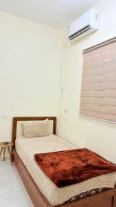 a bed with a wooden frame in a room with a window at هوستل خدمه مبيت in Disah