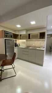 a kitchen with a table and a chair and a sink at Studio na Morada do Sol in Piratuba
