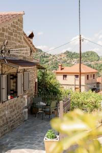 Un patio de una casa con una mesa y sillas. en Armonia Pramanta Mountain Tzoumerka, en Pramanta