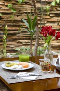 a table with a plate of food and a vase with flowers at Intercity Cuiabá in Cuiabá +14 photos