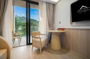 Camera con TV, tavolo e balcone. di 2229 Wyndham Gardens Elegant Studio Forrest View a Nai Thon Beach