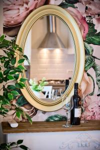 a mirror on a shelf with a bottle and a wine glass at Charming French Getaway Spacious Apartment with Garden and Parking in Dumbrăviţa +84 photos