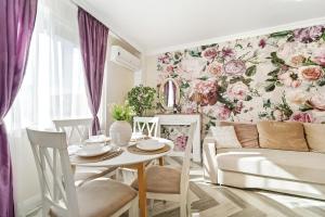 a dining room with a floral wall mural at Charming French Getaway Spacious Apartment with Garden and Parking in Dumbrăviţa