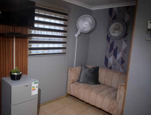 a living room with a couch and a fan at Hlurile Lodge in Vosloorus