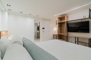 a bedroom with a large bed and a flat screen tv at Aurea Cabo Branco Beach in João Pessoa